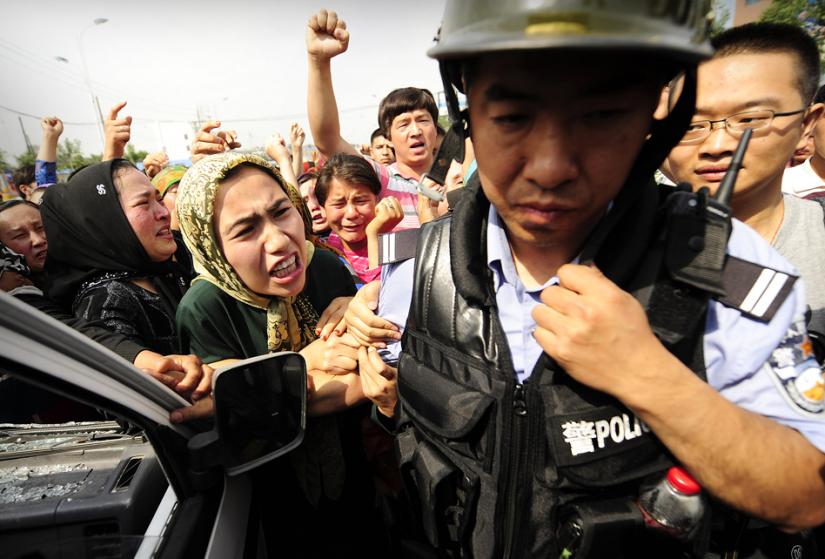 Uighur women protesters challenge Chinese riot police during demonstrations in western Xinjiang province