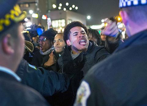 Protesters face lines of police in Chicago after the release of dash-cam video of gruesome murder