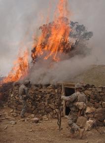 U.S. soldiers burn down a house suspected of being used by the Taliban