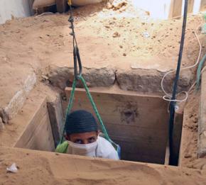 A Palestinian worker is lowered into a tunnel between Gaza and Egypt.