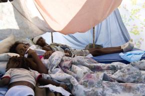 Injured people take shelter in makeshift tents outside of the general hospital in Port-au-Prince