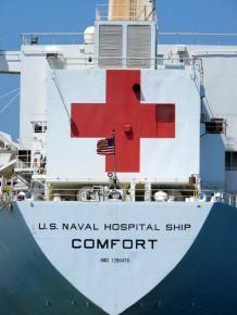A U.S. Navy ship bearing the Red Cross logo