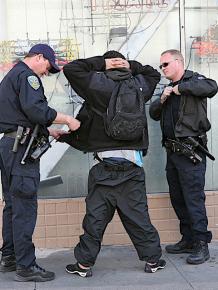 New York police search the pockets of a man stopped on the street