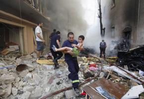 A rescue worker carries a child away from the scene of the car bomb attack in Beirut