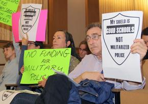 Activists with the Facing Urban Shield Action Network protest during a hearing in Oakland