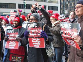 Interfaith workers and their supporters rally against the threat of the medical center's closure