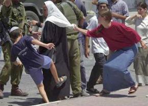 Israeli settlers, protected by IDF soldiers, attack a Palestinian woman