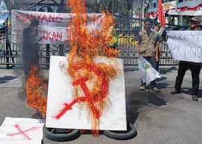 Anti-communists burn a symbol of communism at a rally in West Java