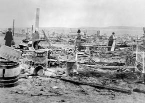 Survivors of the 1914 Ludlow Massacre survey the ruins of the strikers' protest camp