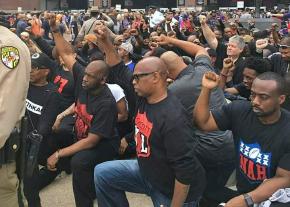 Anti-racist activists take a knee in solidarity outside the Baltimore Ravens stadium