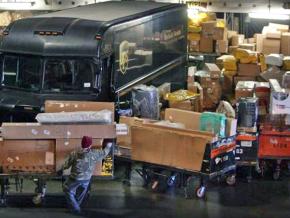A UPS employee loads packages at a regional hub in Ontario, California