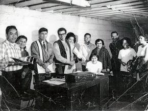 The founding board of the American Indian Movement meets in Minneapolis. Left to right: Harold Goodsky, Charles Deegan, Dennis Banks, Clyde Bellecourt, Peggy Bellcourt, Mr. &amp; Mrs. Barber, Rita Rogers (seated), George Mitchell, Mrs. Mellessy and daughter.